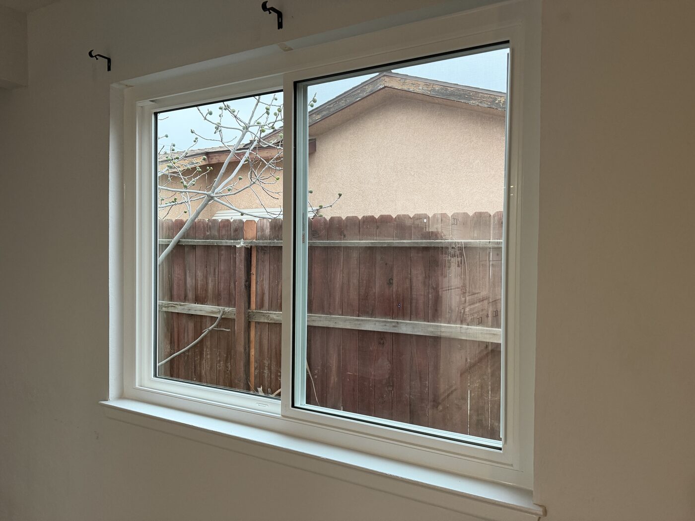 Finished sliding window installation with clean white trim in Fresno, CA